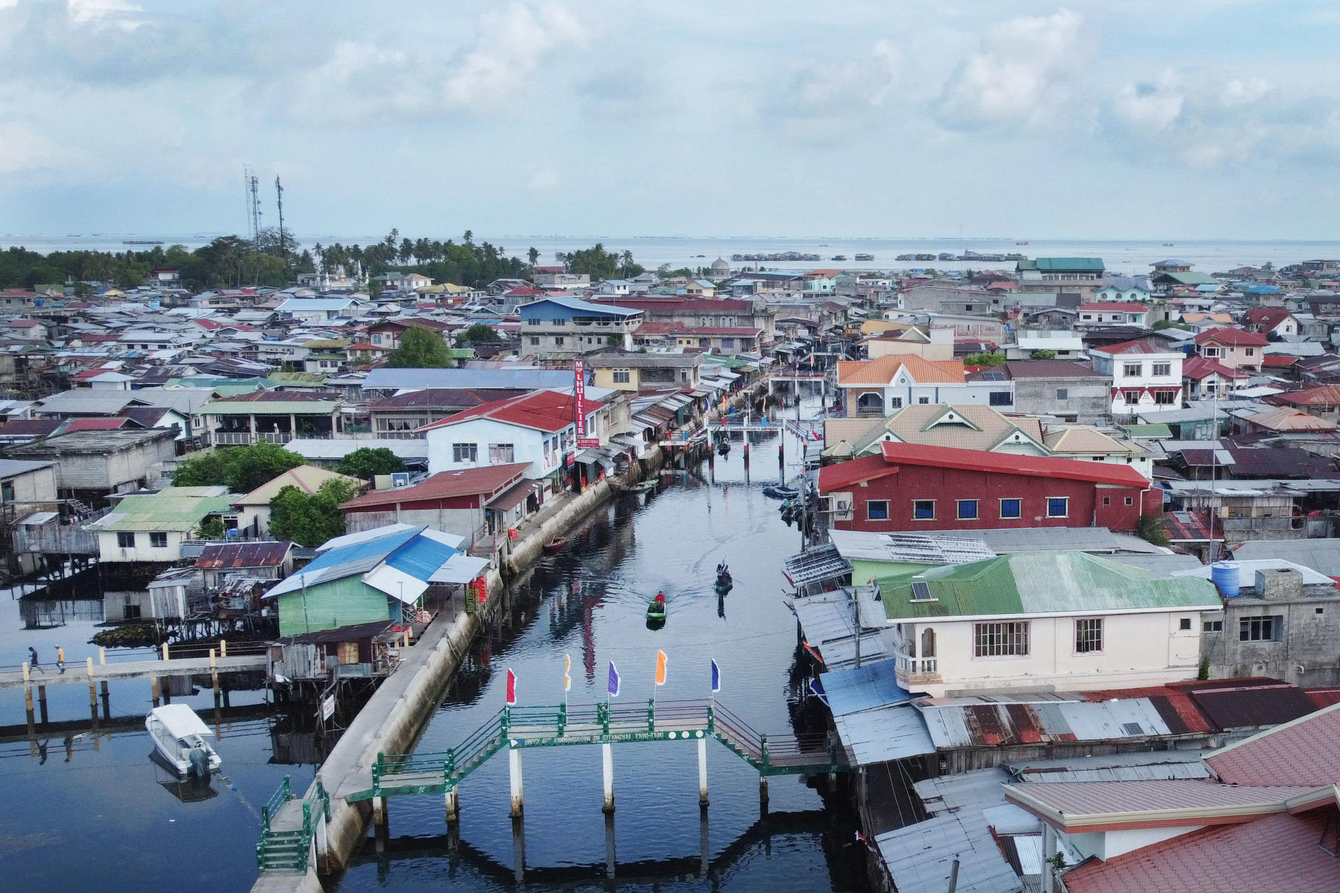 Photograph of a colorful canal town with boats along the water.