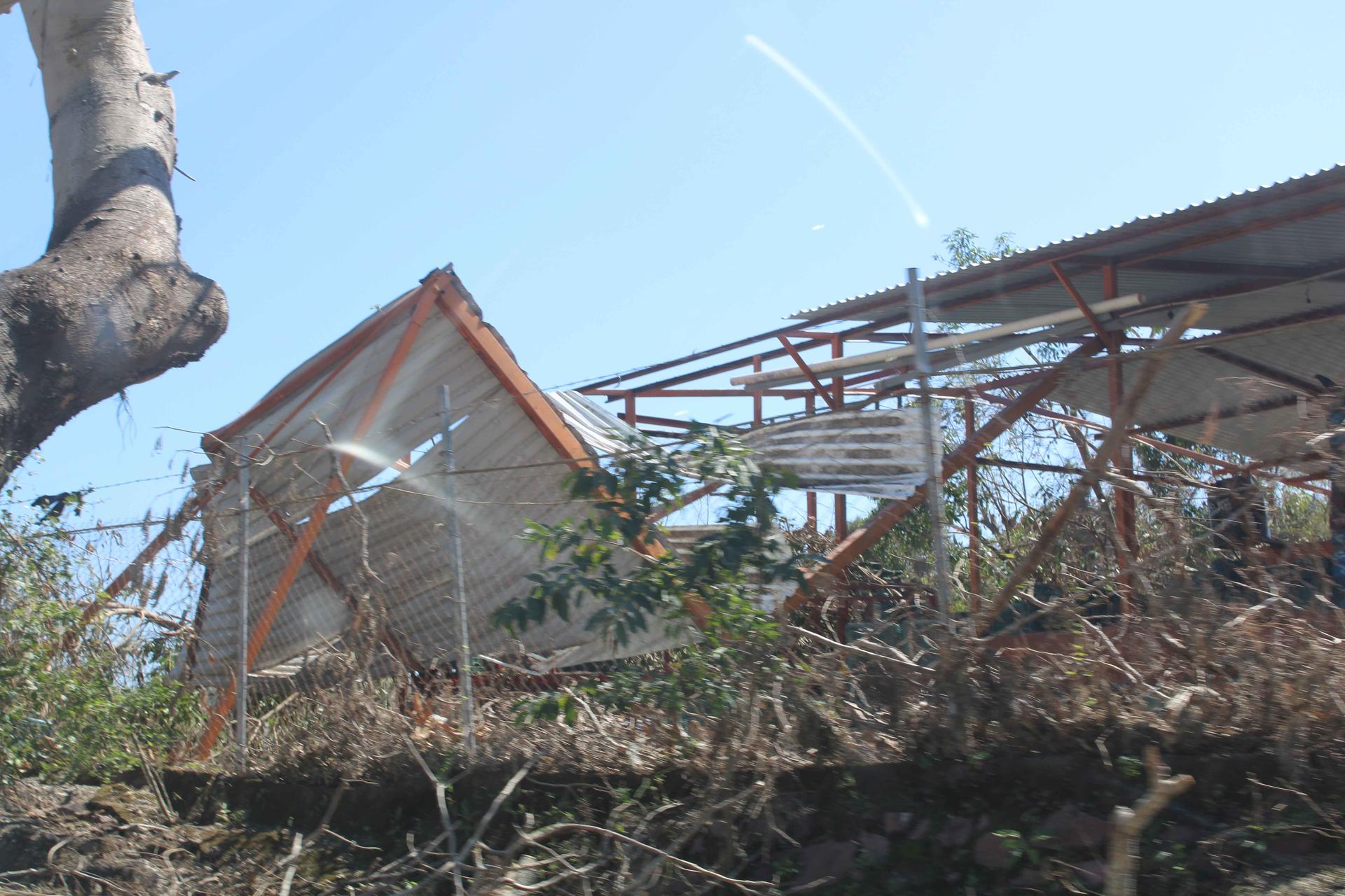 House under construction with wooden framing and scaffolding against a blue sky.