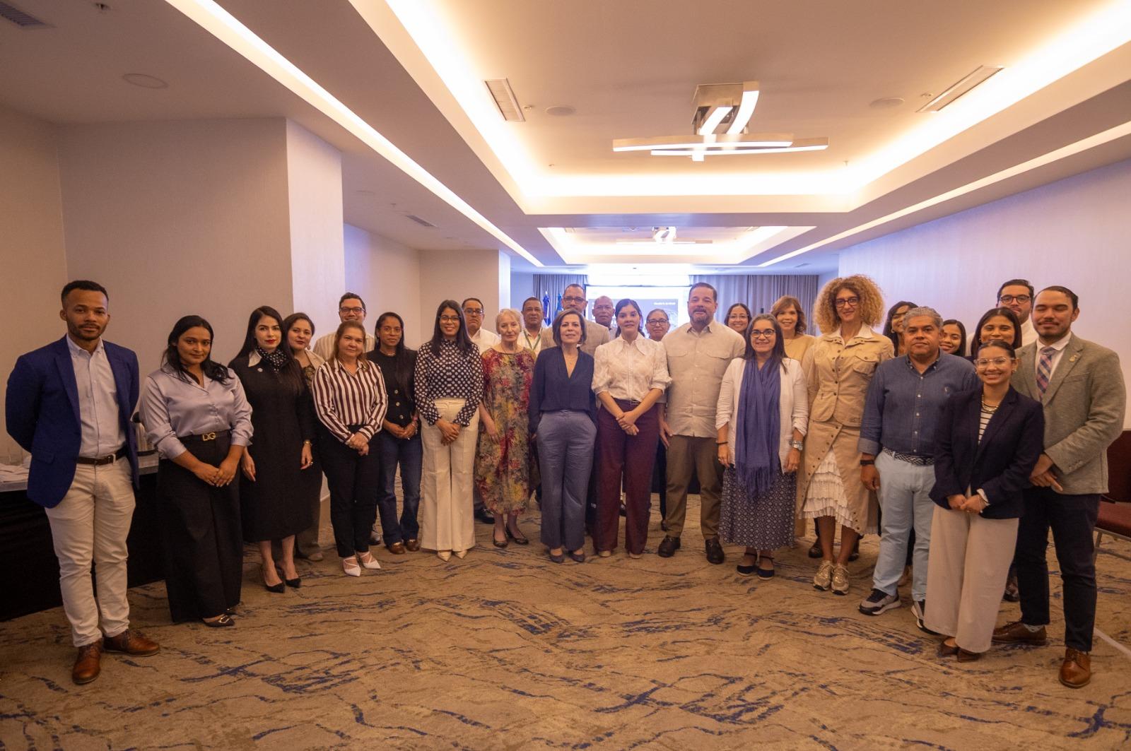 Group of professionals in business attire posing for a group photo in a conference room.