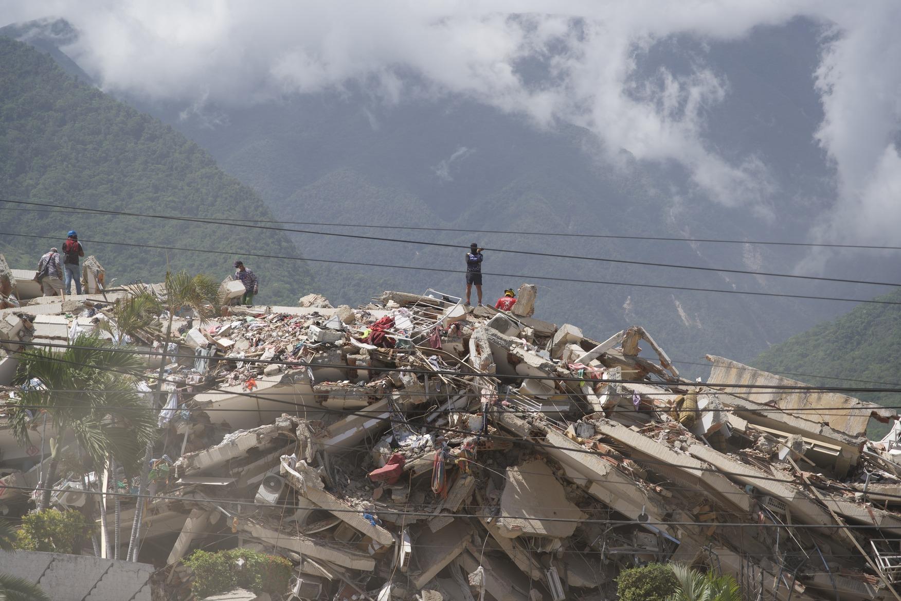 Trabajadores sobre los restos de un edificio colapsado en La Guaira tras los terremotos de junio