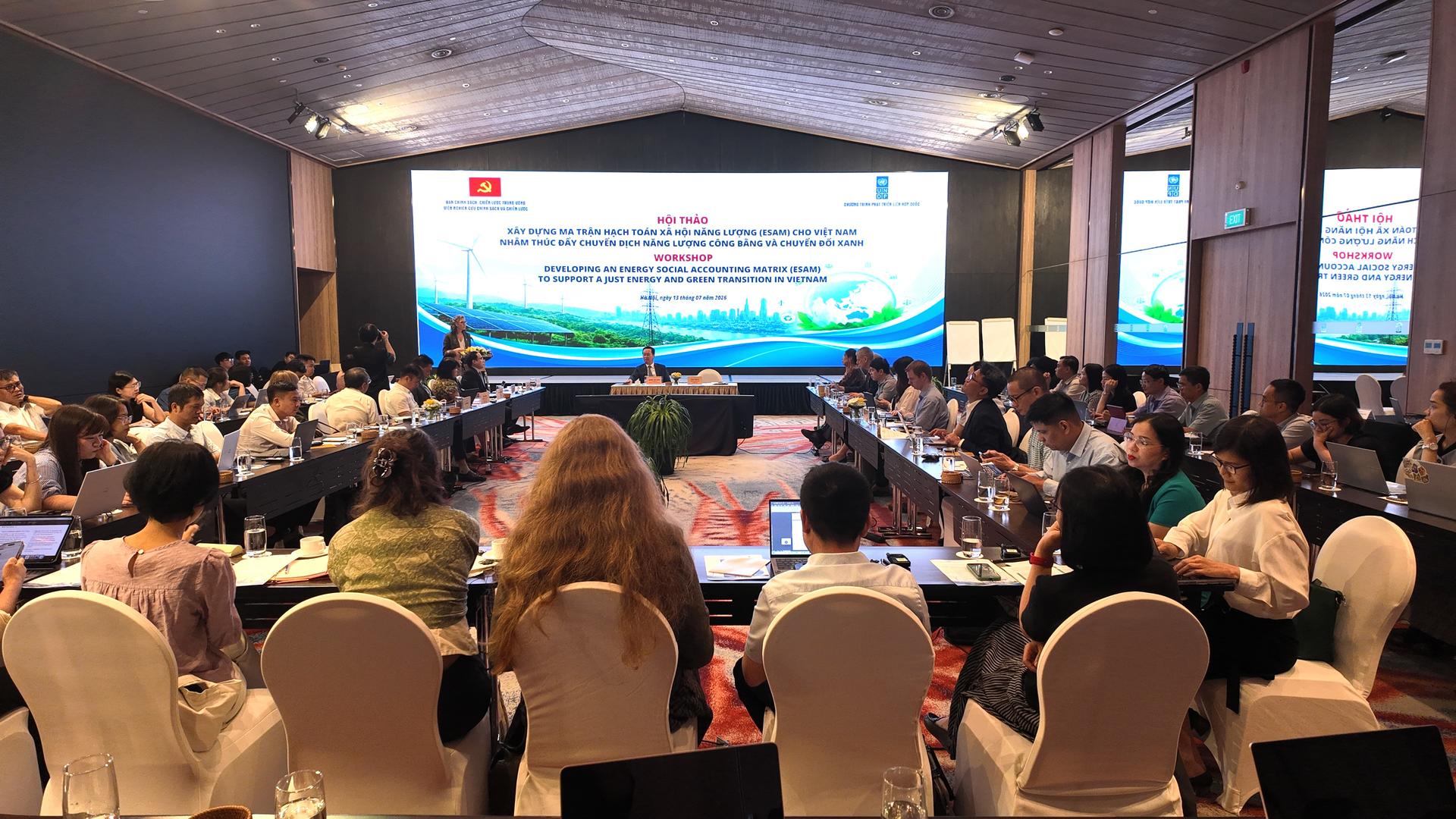 Conference hall filled with attendees watching a stage presentation on a large screen.