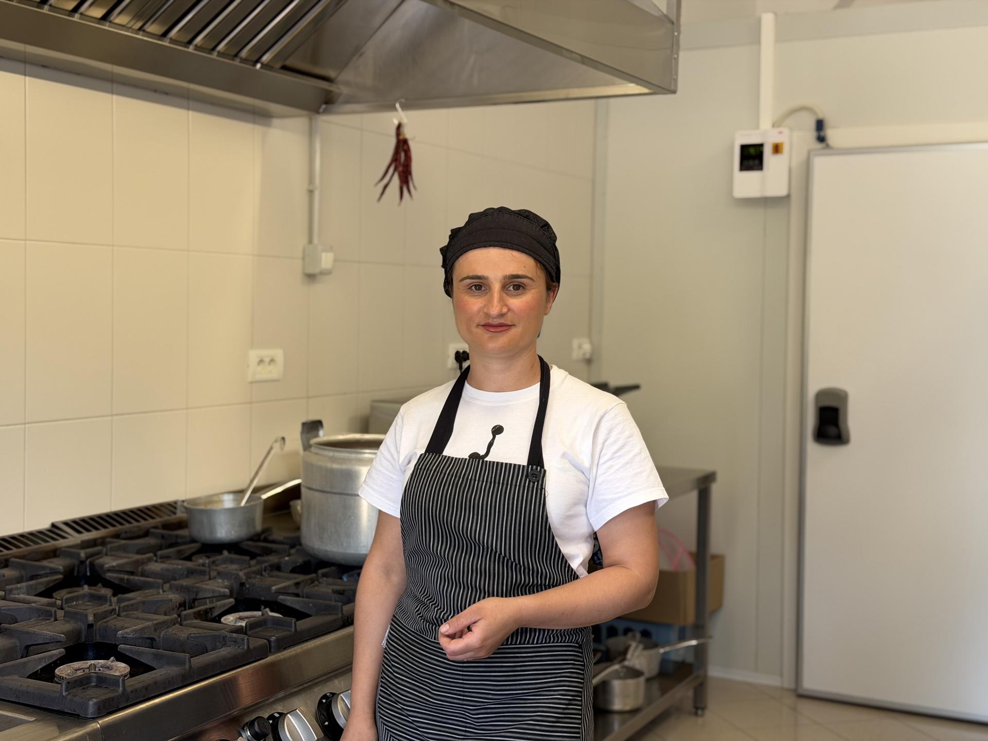 Altina Paloka, 29, works in a professional kitchen after completing vocational culinary training supported through the Joint SDG Fund, which helped her gain confidence, practical skills, and full-time employment.