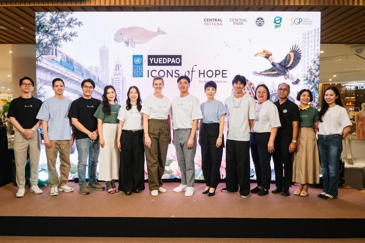 Diverse group posing on stage with an event banner in the background.