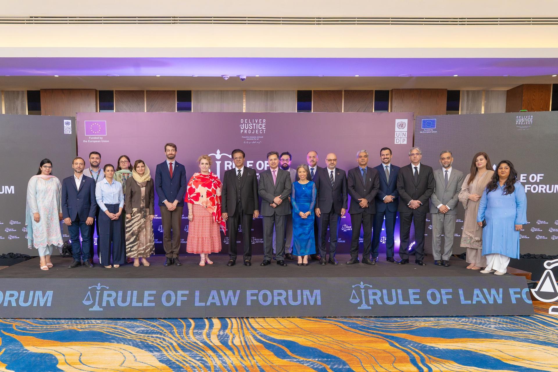 Group of formally dressed attendees on stage at the Rule of Law Forum.
