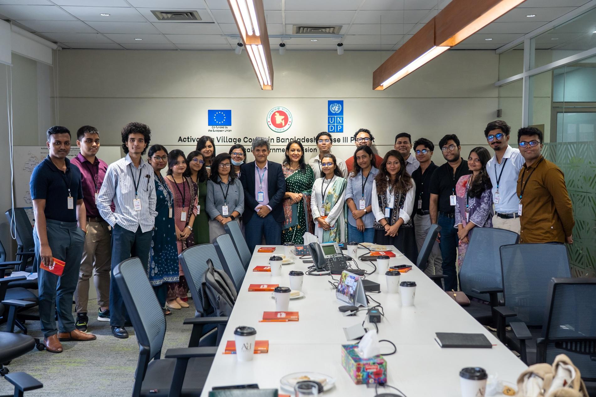 Diverse group of colleagues posing for a photo around a long conference table.