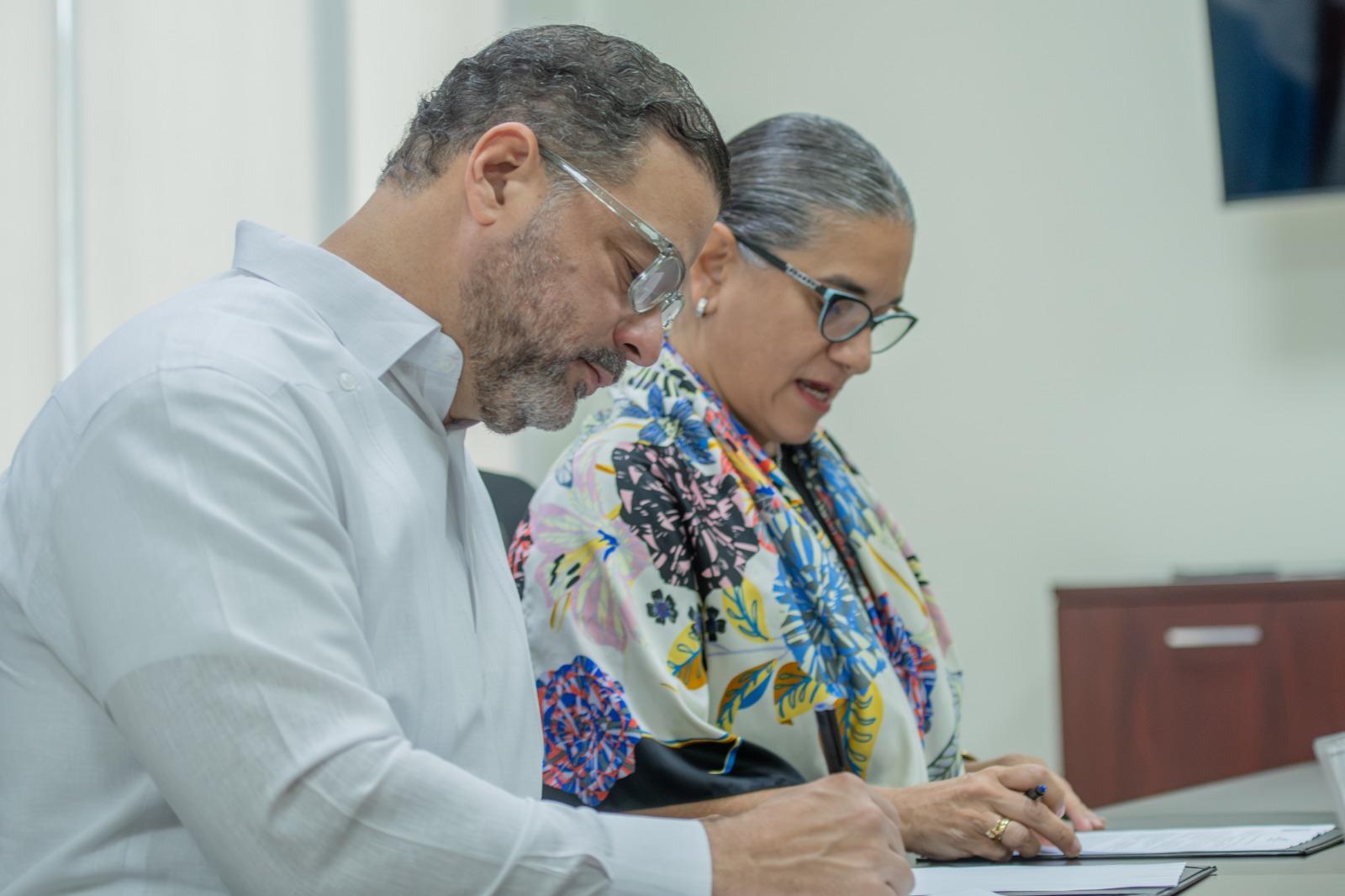Two professionals, a man and a woman, review documents at a desk.