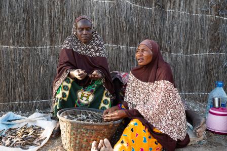 2 femmes devant un panier de poisson séché
