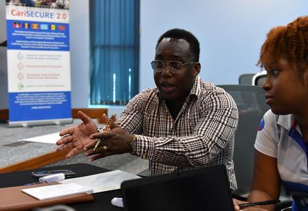 Man participating in discussion while woman looks on.