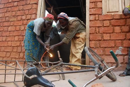A man and a woman work together to repair a bicycle
