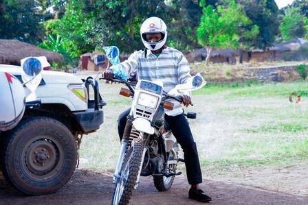 un homme à moto sur un chemin de terre