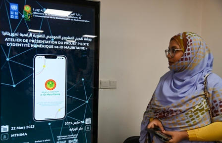 Woman in hijab stands in front of media presentation