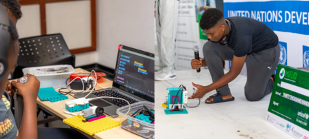 a young boy using a laptop computer sitting on top of a table