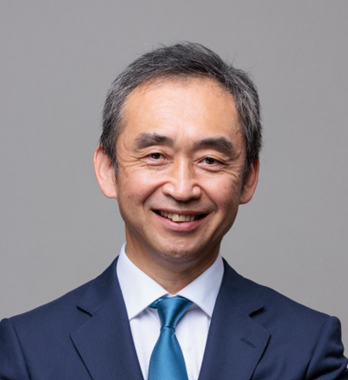 スーツとネクタイを着てカメラに向かって微笑む男性