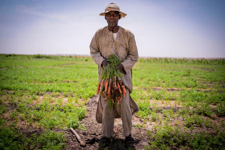 a man standing on top of a grass covered field