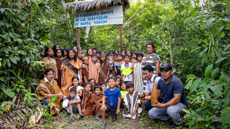 a group of people standing in front of a tree
