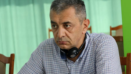 a man sitting in a chair talking on the phone