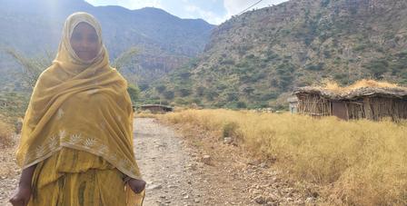 a woman standing in front of a mountain