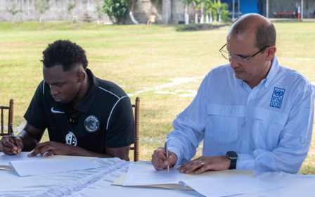 Richard Barathe, Representante Residente del PNUD en Honduras y el delantero hondureño Alberth Elis firmando carta de intención
