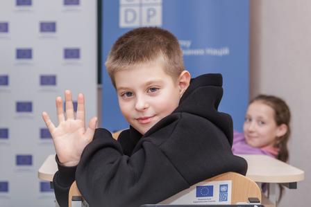 a young boy holding a sign