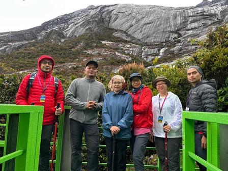 a group of people standing in front of a mountain
