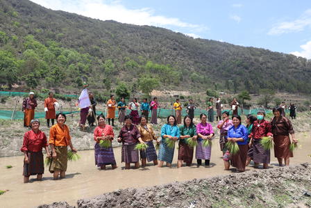 a group of people walking down a dirt road