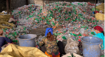 a group of people working at a recycling plant
