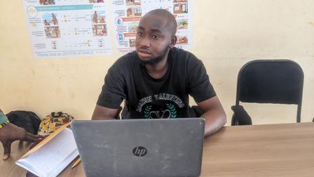 a man sitting at a table using a laptop computer