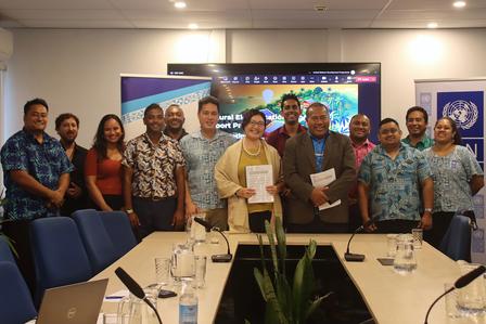 A diverse group of professionals stands together in a conference room, smiling.