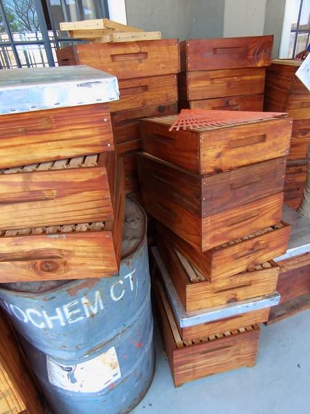 a pile of wooden boxes for packing honey jars