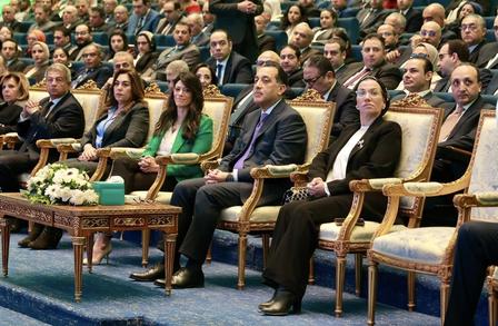 A formal gathering with seated attendees, focused on a few individuals in ornate chairs.