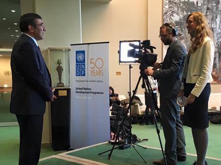 A man being interviewed by a camera crew in a professional setting.