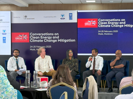 Panel discussion on clean energy and climate change, featuring five speakers set against a backdrop.