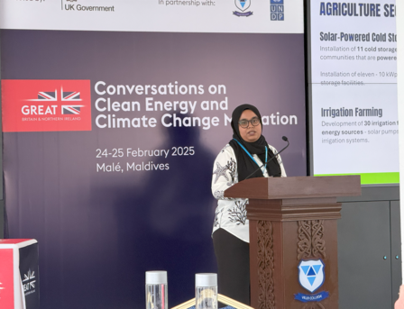 A woman speaks at a podium during a clean energy and climate change conference.