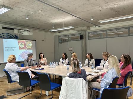 Group of women engaged in a discussion around a conference table in a modern office.