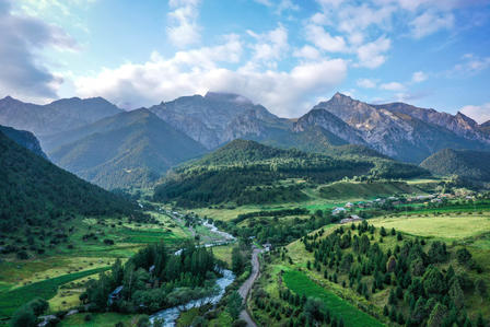 Lush green landscape with mountains in the background and a winding river below.