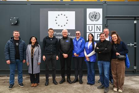 Group of people in front of a UNFPA logo, standing together in a casual outdoor setting.