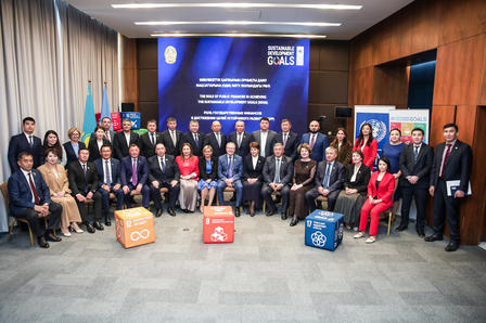 Group photo of diverse attendees in formal attire, posing in a conference room setting.
