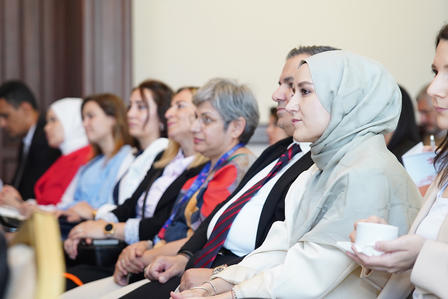 A diverse group of attendees seated in a seminar, focused and engaged.