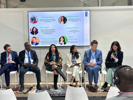 A panel discussion featuring five speakers seated on chairs, with a screen behind them displaying text.(L-R): Henrique Dolabella (Head of Rural Environmental Registry, Government of Brazil), Ynsa Traore (Technical Advisor, Government of Côte d’Ivoire), Sahar Albazar (Member of Parliament, Egypt), Akanksha Sharma (Head of Climate Tech, GSMA), Bjorn-Soren Gigler (Head of Digital and Green Twin Transition, GIZ Germany) and Reina Otsuka (Digital Lead for Climate and Nature, UNDP) speak at a roundtable on Natur