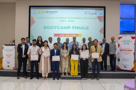 Group of participants holding certificates at a bootcamp finale event, with a banner in the background.