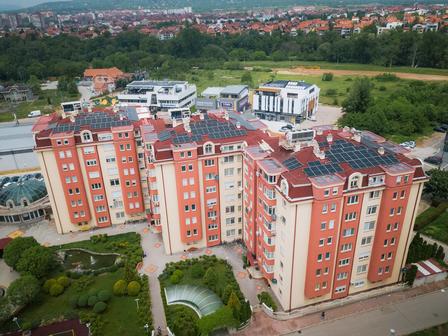 Aerial view of modern residential buildings with solar panels and landscaped greenery.
