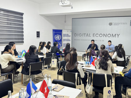 A group of students listens to speakers at a digital economy workshop.