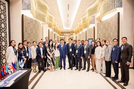 Group photo of diverse professionals posing in a spacious, elegantly designed hallway.
