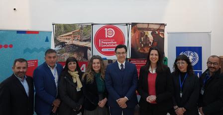 Nine professionals standing together for a group photo in front of backdrop displays.