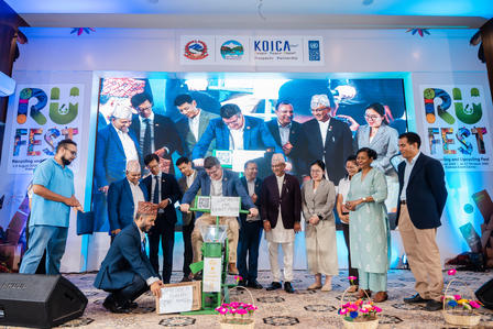 A diverse group of people gathered on stage at an event, celebrating with smiles and a trophy.