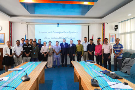 Group photo of participants in a workshop, smiling in a conference room.