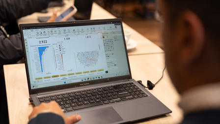A person viewing data visualizations on a laptop in a café setting.