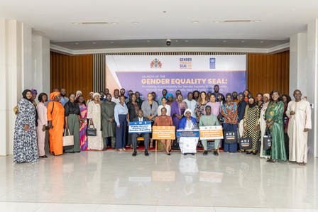 Group of people posing on stage at a gender equality seal ceremony.
