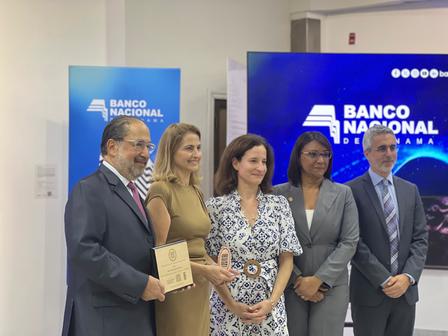 Cinco personas posan en un evento del Banco Nacional con un pantalla azul al fondo