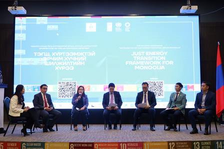 Panel discussion on stage with several people seated; blue backdrop with text and a Russian flag.